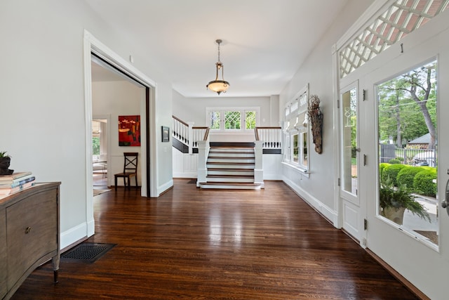 foyer with stairway, wood finished floors, and baseboards