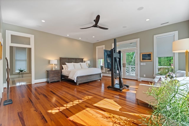 bedroom with wood finished floors, baseboards, access to exterior, and recessed lighting