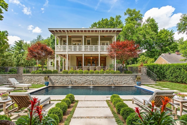 back of property with stairs, fence, and a patio