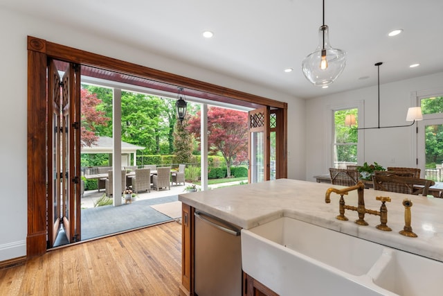 kitchen featuring a sink, light wood-style flooring, recessed lighting, decorative light fixtures, and stainless steel dishwasher