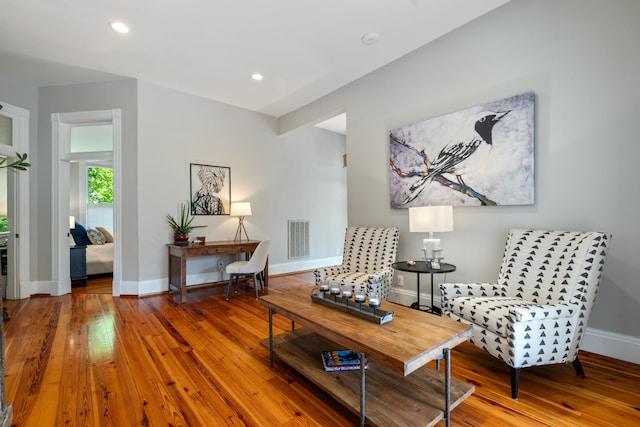 living area featuring wood-type flooring, baseboards, and recessed lighting