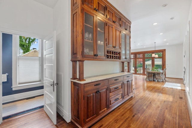 corridor featuring plenty of natural light, wood finished floors, baseboards, and recessed lighting