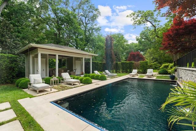 view of pool with a patio area, an exterior structure, an outbuilding, and fence