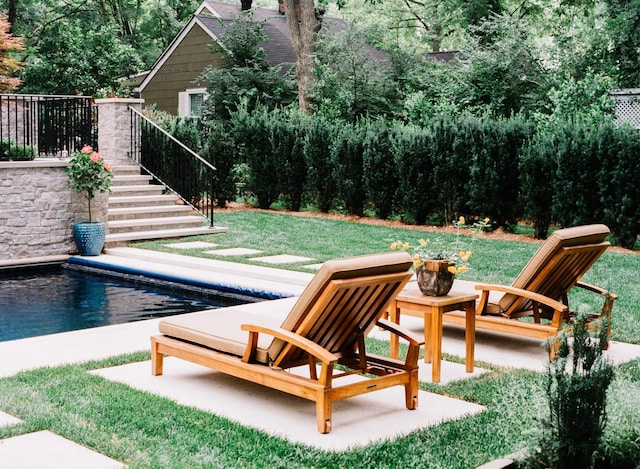 view of swimming pool with a yard, a patio, and stairway