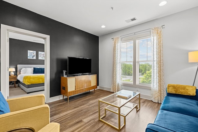 living room with wood finished floors, recessed lighting, and baseboards