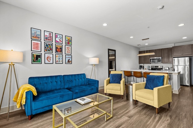 living area with dark wood-type flooring, baseboards, and recessed lighting