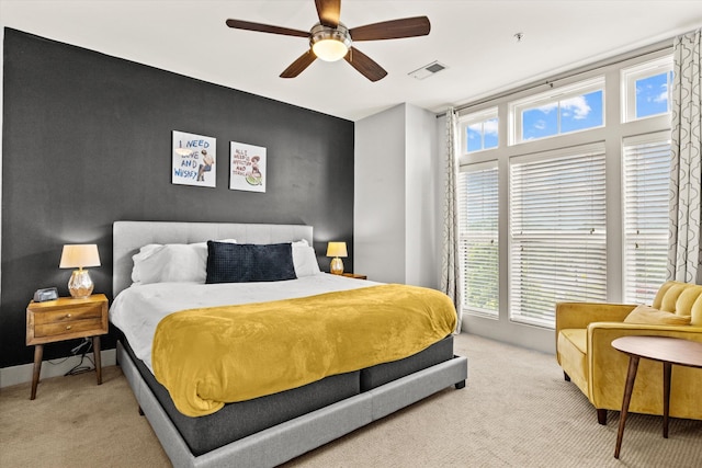 bedroom featuring carpet flooring, multiple windows, and a ceiling fan