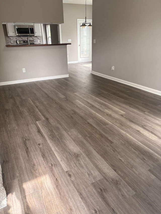 2642 Sewanee Pl, Murfreesboro, TN 37128 - unfurnished living room with dark wood finished floors, baseboards, and a chandelier
