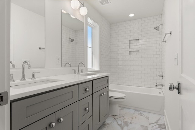 bathroom with marble look tile flooring, toilet, bathing tub / shower combination, and double vanity