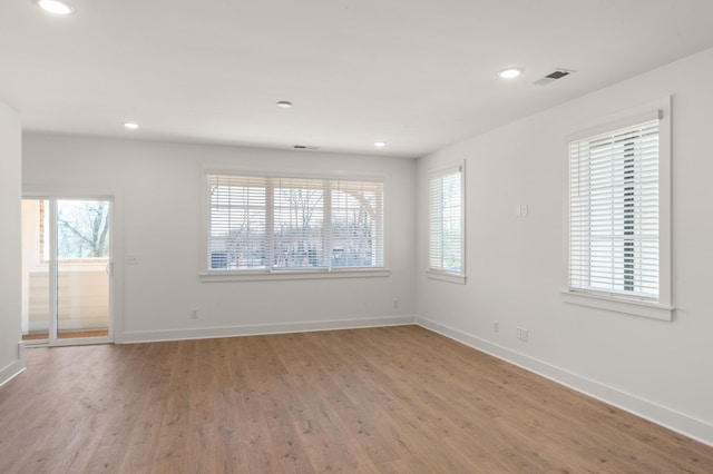unfurnished room with baseboards, light wood-type flooring, and recessed lighting