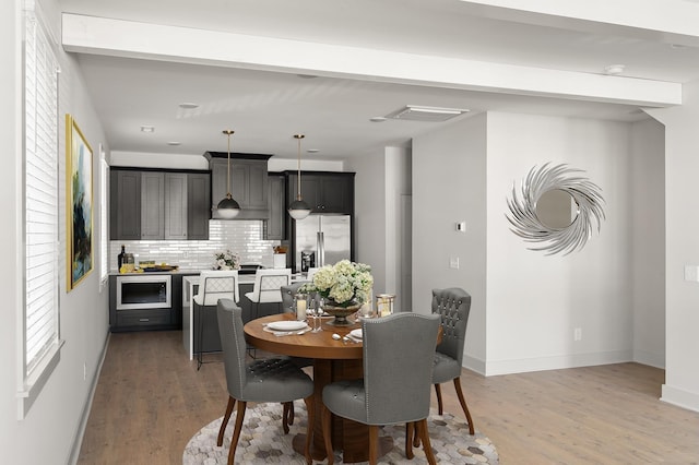 dining space with light wood-type flooring and baseboards