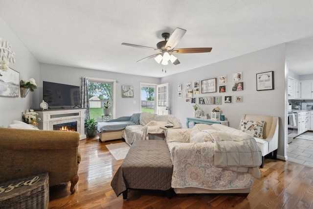 405 Mockingbird Dr, Mount Pleasant, TN 38474 - living room featuring ceiling fan, a lit fireplace, and wood finished floors