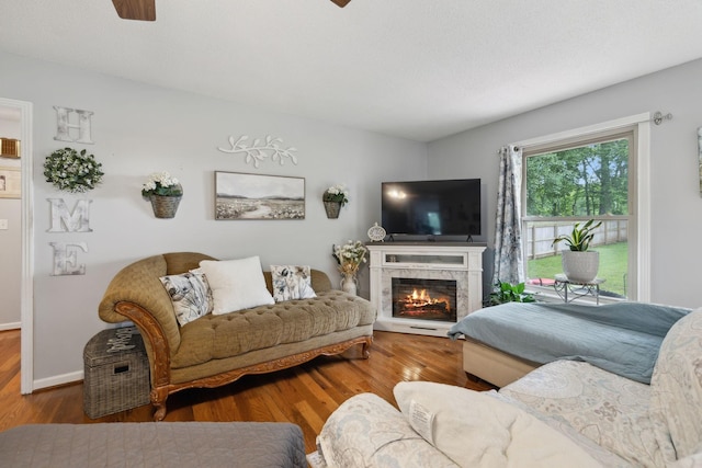405 Mockingbird Dr, Mount Pleasant, TN 38474 - living area with a ceiling fan, wood finished floors, a lit fireplace, and baseboards