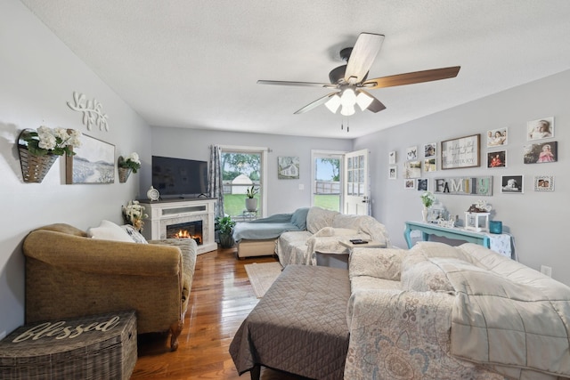 405 Mockingbird Dr, Mount Pleasant, TN 38474 - living area with wood finished floors, a ceiling fan, a lit fireplace, and a textured ceiling