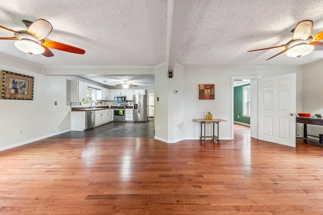 2046 Scribners Mill Rd, Culleoka, TN 38451 - unfurnished living room with ceiling fan, crown molding, wood finished floors, a textured ceiling, and a sink