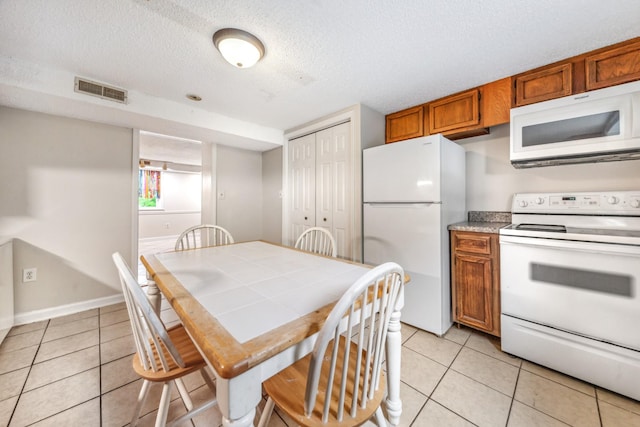 2046 Scribners Mill Rd, Culleoka, TN 38451 - kitchen featuring white appliances, light tile patterned flooring, brown cabinets, a textured ceiling, and tile counters
