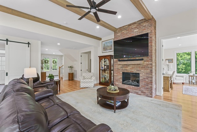 304 Cedar Hollow Ct, Lebanon, TN 37087 - living area featuring wood finished floors, ceiling fan, a barn door, beamed ceiling, and a brick fireplace