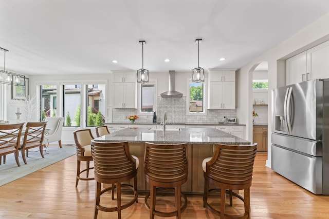 304 Cedar Hollow Ct, Lebanon, TN 37087 - kitchen with stainless steel fridge with ice dispenser, wall chimney exhaust hood, tasteful backsplash, light wood-style flooring, and a sink