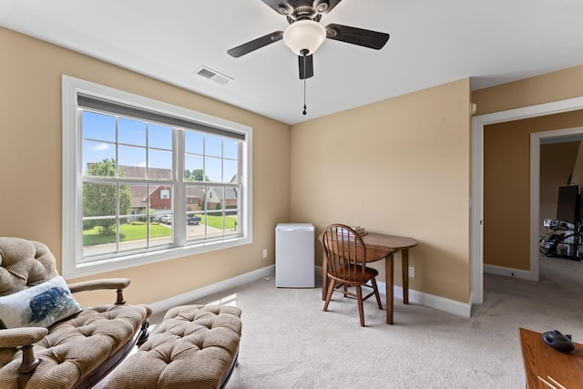 living area with light colored carpet, baseboards, and ceiling fan