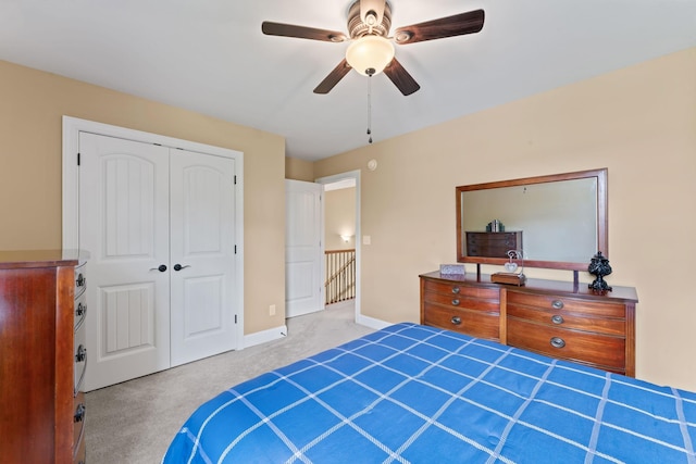 carpeted bedroom with a closet, ceiling fan, and baseboards