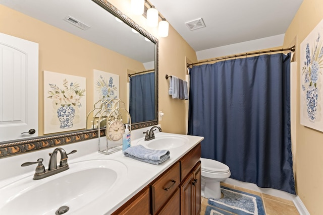 bathroom featuring toilet, tile patterned flooring, and double vanity