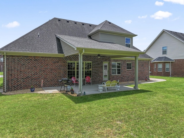 back of house with a patio, brick siding, a shingled roof, and a yard