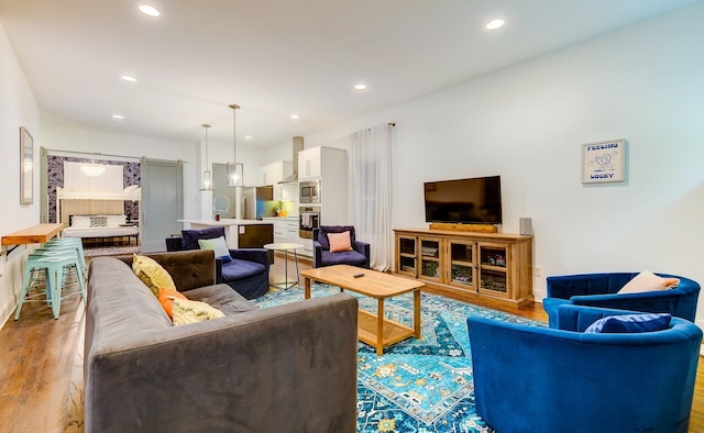 living area with light wood-type flooring and recessed lighting