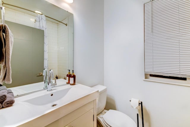 full bathroom with toilet, vanity, and a shower
