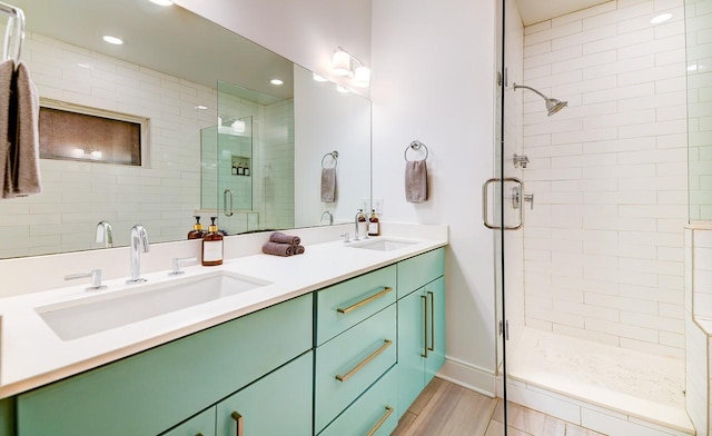bathroom with a shower stall, double vanity, recessed lighting, and wood finished floors