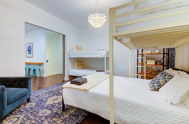 bedroom featuring wood finished floors and a chandelier