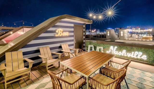balcony at night featuring outdoor dining area
