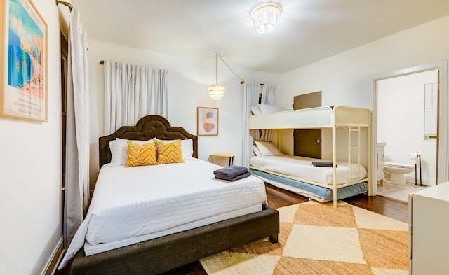 bedroom featuring wood finished floors and ensuite bathroom