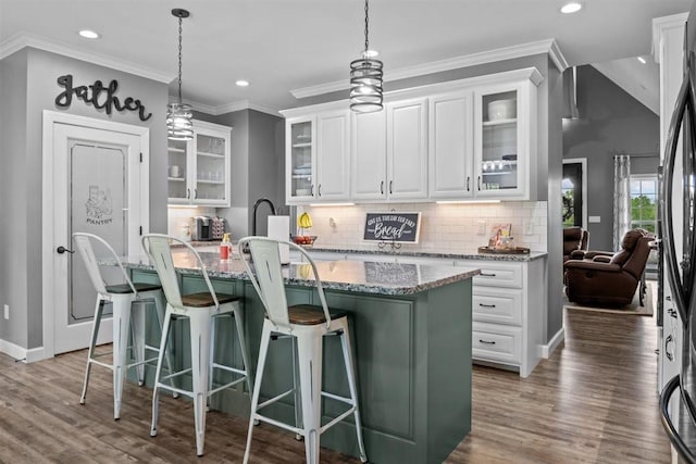 3571 Old Blacktop Rd, Mc Ewen, TN 37101 - kitchen featuring wood finished floors, recessed lighting, decorative backsplash, light stone counters, and a kitchen island with sink