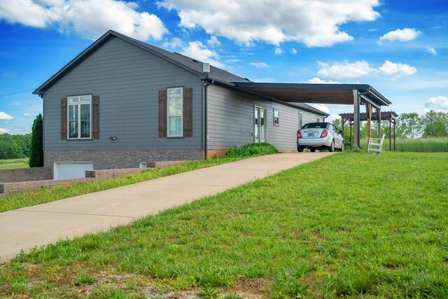 82 Staggs Rd, Ethridge, TN 38456 - view of side of home with driveway, a carport, and a lawn