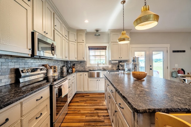 82 Staggs Rd, Ethridge, TN 38456 - kitchen with stainless steel appliances, a sink, dark wood-style flooring, tasteful backsplash, and decorative light fixtures