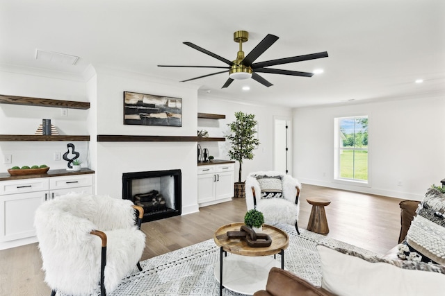 358 Coopertown Rd, Unionville, TN 37180 - living area with crown molding, a ceiling fan, a fireplace, light wood-style flooring, and recessed lighting