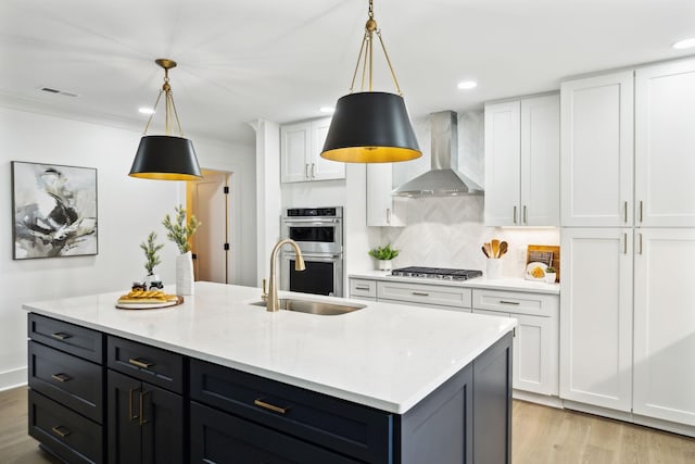 358 Coopertown Rd, Unionville, TN 37180 - kitchen featuring wall chimney range hood, stainless steel appliances, a sink, light wood-type flooring, and white cabinets