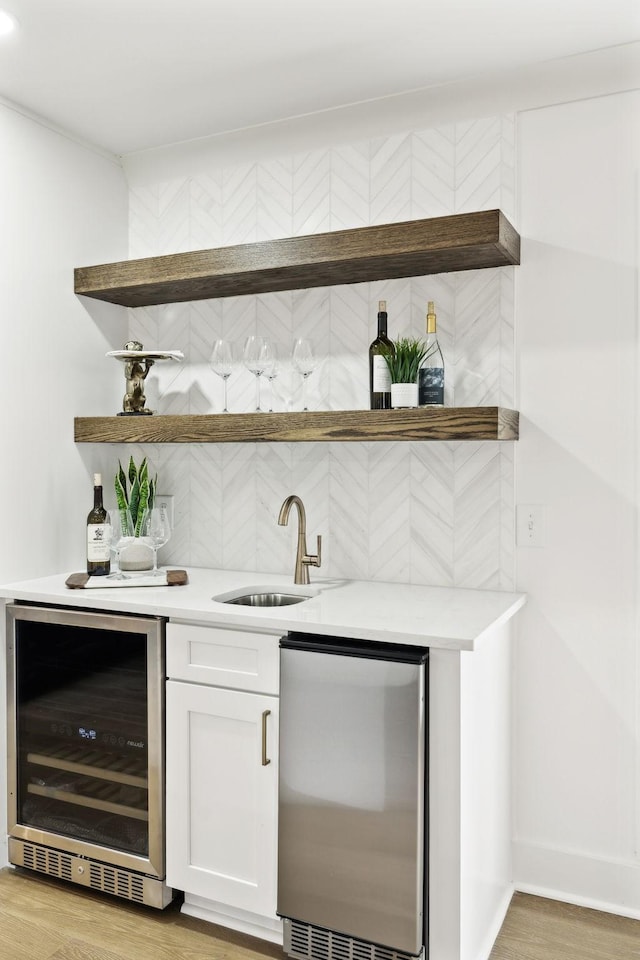 358 Coopertown Rd, Unionville, TN 37180 - indoor wet bar with wine cooler, stainless steel fridge, light wood finished floors, baseboards, and decorative backsplash