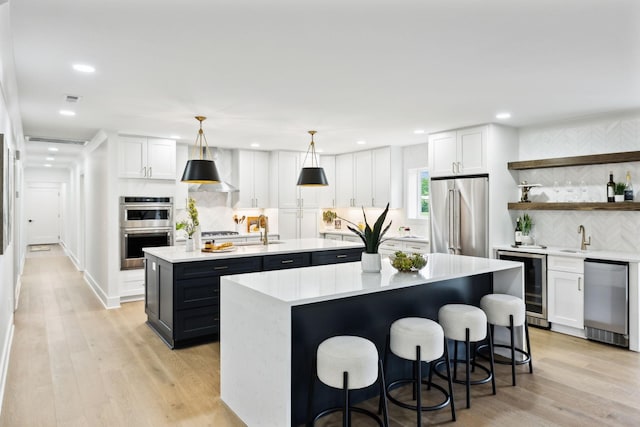 358 Coopertown Rd, Unionville, TN 37180 - kitchen with wine cooler, stainless steel appliances, a center island with sink, light countertops, and a sink