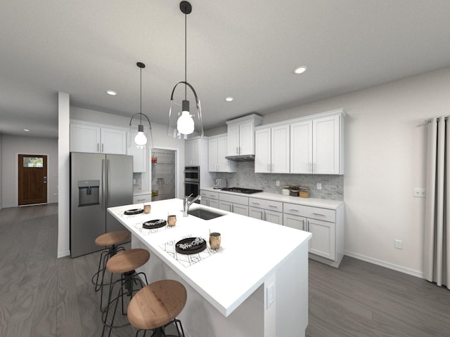 kitchen featuring stainless steel appliances, a sink, wood finished floors, baseboards, and a breakfast bar