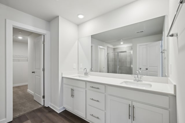 4621 Winslet Dr, Smyrna, TN 37167 - full bathroom featuring a stall shower, double vanity, a spacious closet, wood finished floors, and baseboards