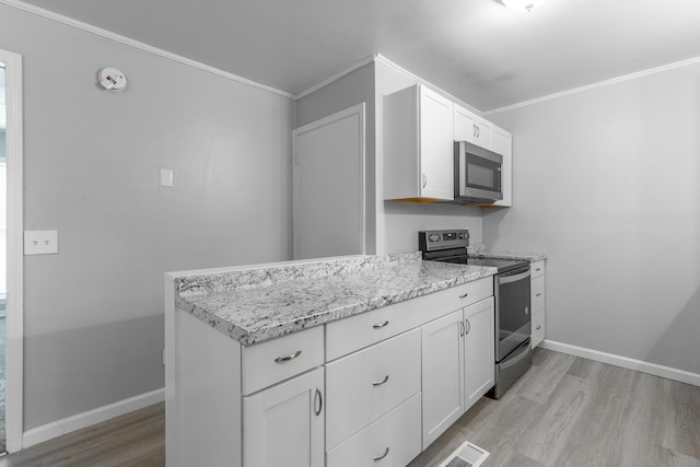 kitchen with appliances with stainless steel finishes, light wood-style flooring, ornamental molding, white cabinetry, and baseboards