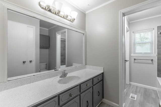 full bath with ornamental molding, toilet, baseboards, vanity, and wood finished floors