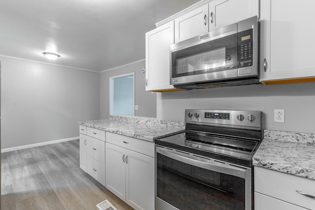 kitchen with stainless steel appliances, light wood finished floors, white cabinetry, and light stone countertops