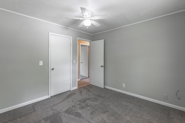 unfurnished bedroom featuring carpet, ornamental molding, baseboards, a ceiling fan, and a textured ceiling