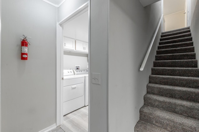stairway with washer and clothes dryer and wood finished floors