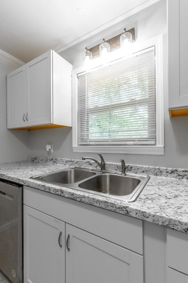 kitchen with dishwasher, a sink, light countertops, white cabinets, and ornamental molding