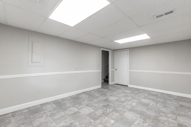 finished basement featuring a drop ceiling and baseboards