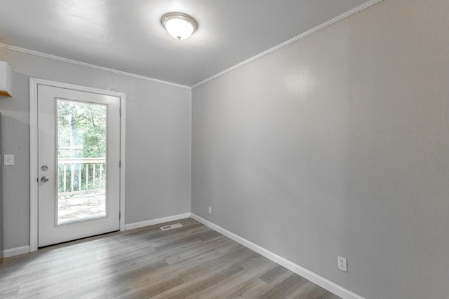 spare room with wood finished floors, baseboards, and ornamental molding