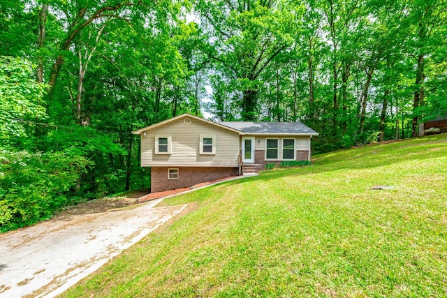 ranch-style home with brick siding, a front yard, and driveway